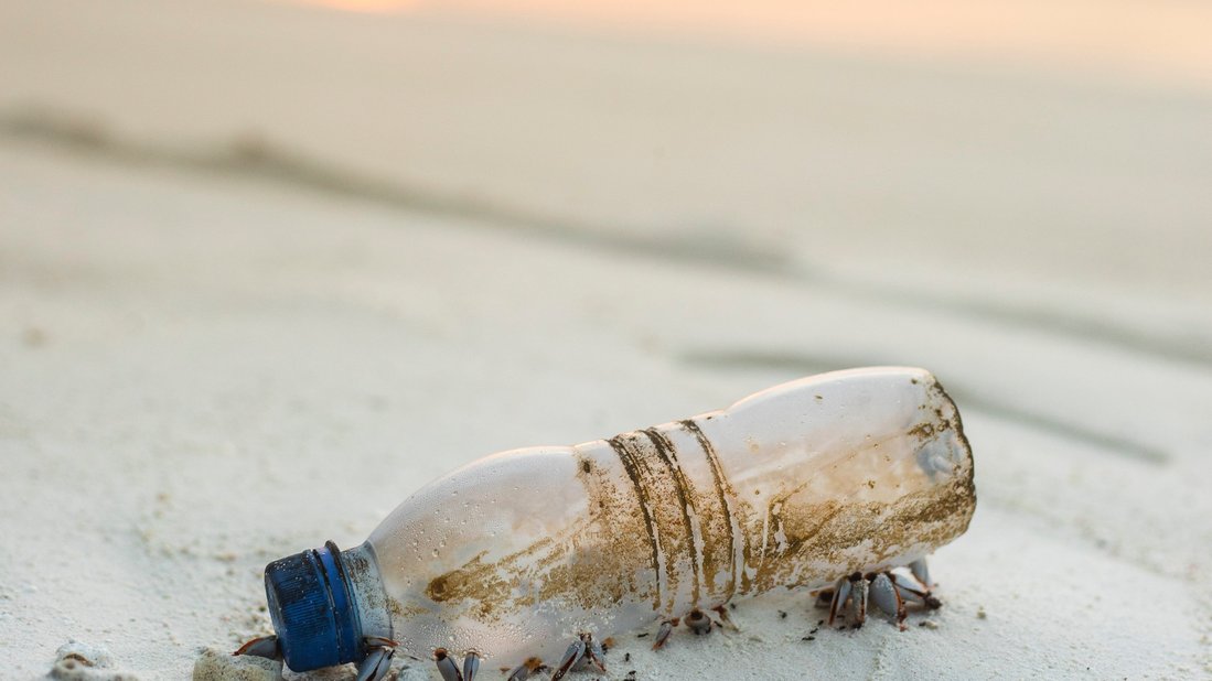 Durchsichtige Plastikflasche am Strand