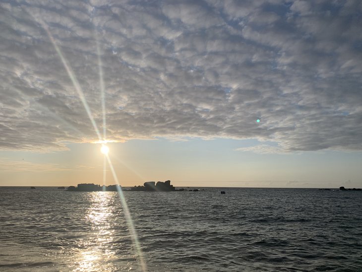 Die Sonne schaut unter den Wolken über dem Atlantik hervor. 