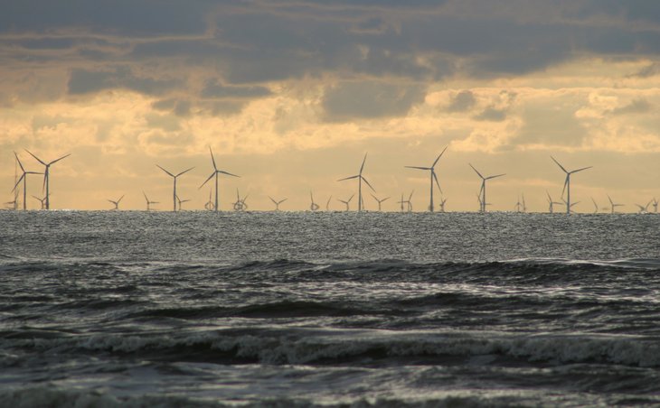 Ein Offhore Windpark ist am Horizont zu sehen.