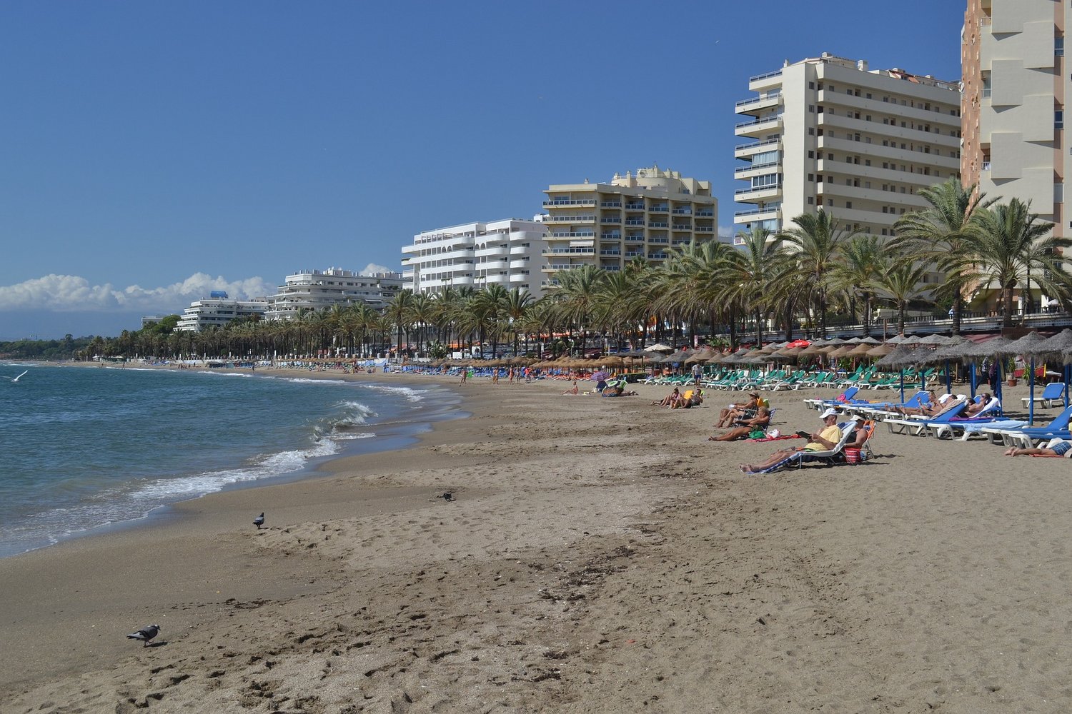 Strand mit Hotelburgen im Hintergrund.